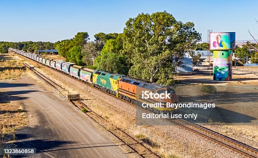 istock Aerial view, grain train passing public art mural on old water tower 1323860858