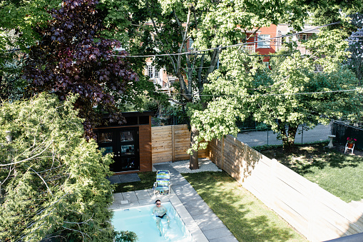Aerial View Of A Backyard With A Man In A Swimming Pool Stock