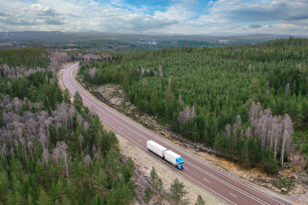 flygfoto av en lastbil på en motorväg genom ett skogslandskap - european highway drone bildbanksfoton och bilder