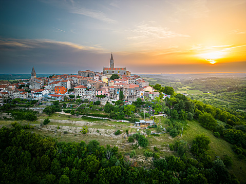 Aerial drone shot of an old medieval town Buje in Istria, Croatia at sunset.with a church tower.