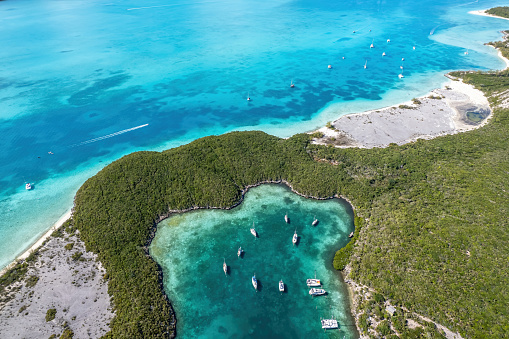 Drone aerial view of anchored sailing yacht in emerald Caribbean sea, Stocking Island, Great Exuma, Bahamas.
