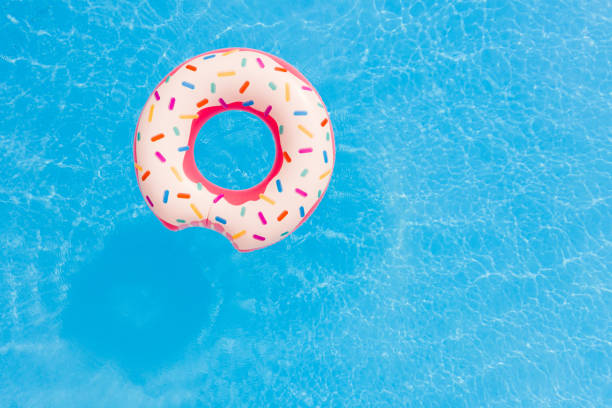 Aerial view of big pink donut in the swimming pool. stock photo