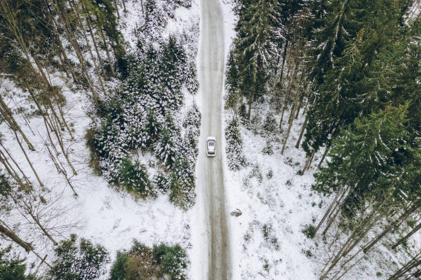 aerial view of car moving by canyon at snowed winter stock photo