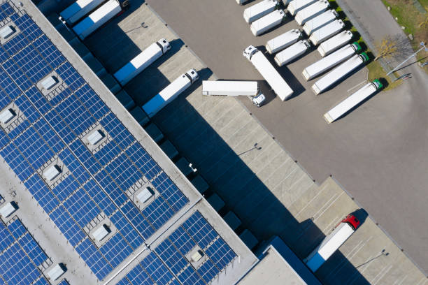 luchtfoto van vrachtcontainers en distributiemagazijn met hernieuwbare energiecentrales - zonnepanelen warehouse stockfoto's en -beelden