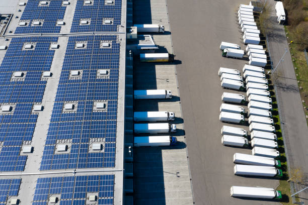 aerial view of cargo containers and distribution warehouse with renewable energy plants - zonnepanelen warehouse stockfoto's en -beelden