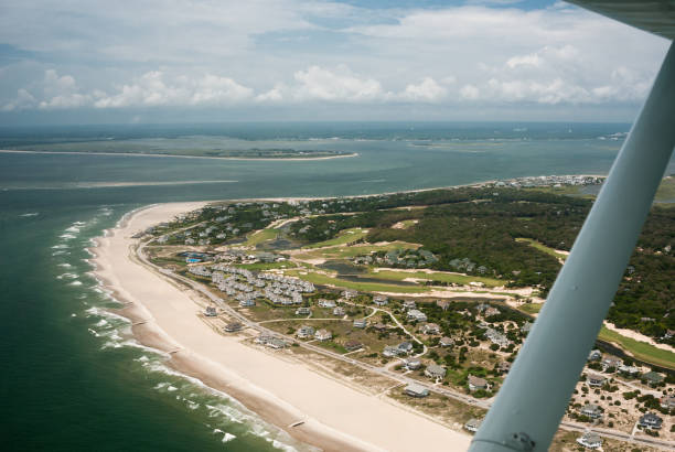 Aerial View of coastline and beach houses from Fixed-wing airplane over Carolina Beach, North Carolina Flying around the Carolina Beach coastline in a small private aircraft reveals the beauty of the shoreline. carolina beach north carolina stock pictures, royalty-free photos & images