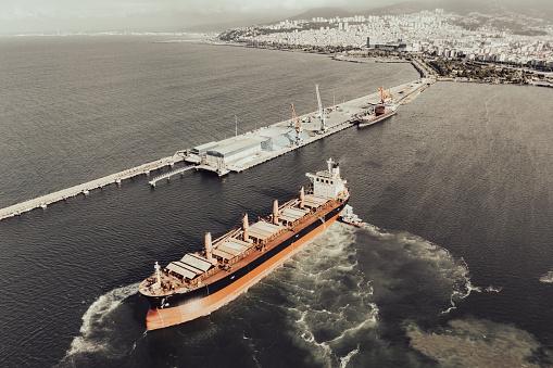 Aerial view of Container freight ship carrying container box for import and export business logistic and transportation by container ship in open sea. Approaching to Mersin international port.