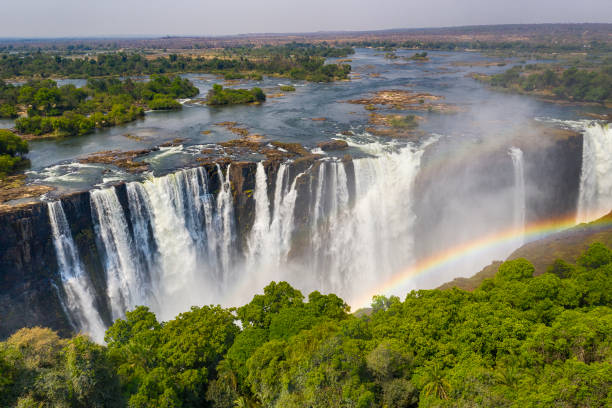 Aerial view of famous Victoria Falls, Zimbabwe and Zambia Aerial few of the world famous Victoria Falls with a large rainbow over the falls. This is right at the border between Zambia and Zimbabwe in Southern Africa. The mighty Victoria Falls at Zambezi river are one of the most visited touristic places in Africa. southern africa stock pictures, royalty-free photos & images