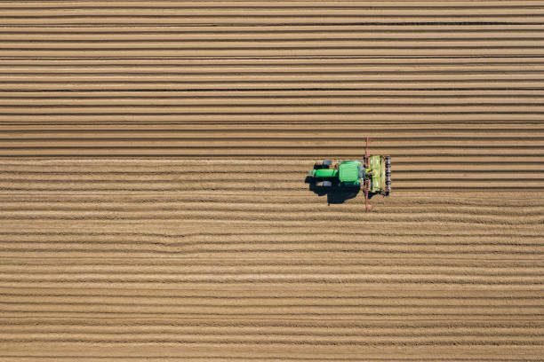 Aerial view of farming tractor plowing and spraying on field.  Agriculture. View from above. Photo captured with drone. stock photo