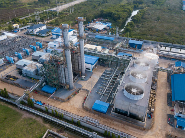 Aerial view of gas turbine power plant factory with cooling system fan in operation that producing electricity while causing pollution and releasing carbon dioxide which create global warming stock photo