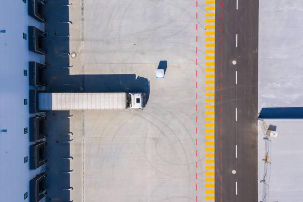 Aerial view of goods warehouse. Logistics center in industrial city zone from above. Aerial view of trucks loading at logistic center. View from drone. stock photo