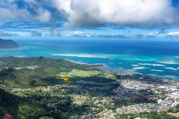 Aerial view of helicopter from high a ridge trail on Oahu, Hawaii overlooking Kaneohe, Kailua and the windward side of the island stock photo