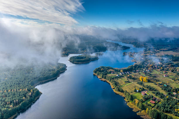 Aerial view of lake and clouds below stock photo