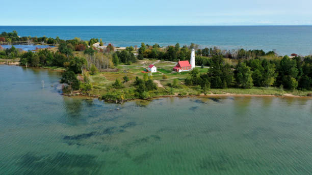 Aerial View of Lake Huron and the Tawas Point Lighthouse Aerial view of the Tawas Point lighthouse on Lake Huron in Tawas Point State Park. erosion control stock pictures, royalty-free photos & images