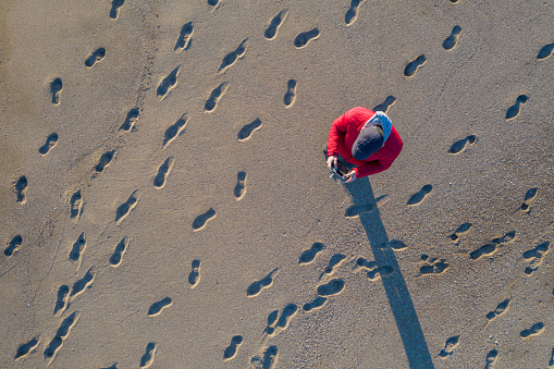 Aerial view of man piloting a drone on tropical beach