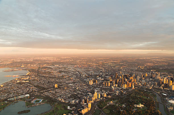 Aerial view of Melbourne downtown at dawn A golden glow covers the Melbourne downtown area at dawn, as seen from a hot air balloon. federation square stock pictures, royalty-free photos & images