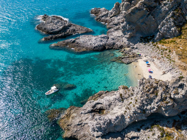 Aerial view of moored boats floating on a transparent sea. Scuba diving and summer holidays. Capo Vaticano, Calabria, Italy. Promontory stock photo