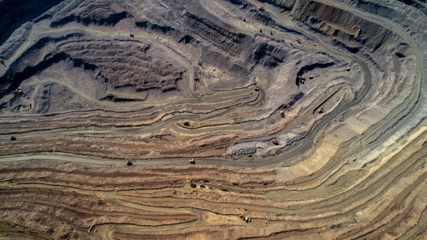 veduta aerea della cava mineraria a cielo aperto con molti macchinari al lavoro. - miniera foto e immagini stock