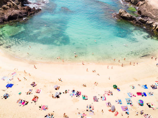Aerial view of people at the beach Aerial view of people at Papagayo beach in Lanzarote canary islands stock pictures, royalty-free photos & images