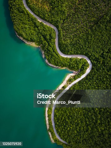 istock Aerial view of scenic mountain road and lake 1325075920