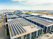 istock Aerial view of solar panels on factory roof. Blue shiny solar photo voltaic panels system product. 1354581999
