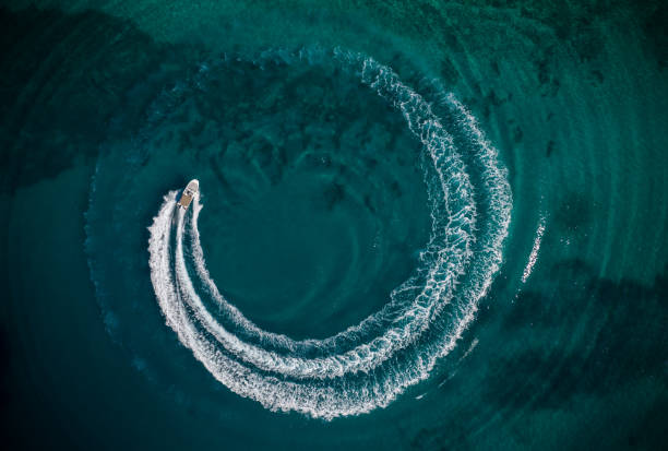 Aerial view of speedboat creating wheel shape Aerial view of speed motor boat in shallow water, creating wheel shape. Travel and leasure activities concept reef photos stock pictures, royalty-free photos & images