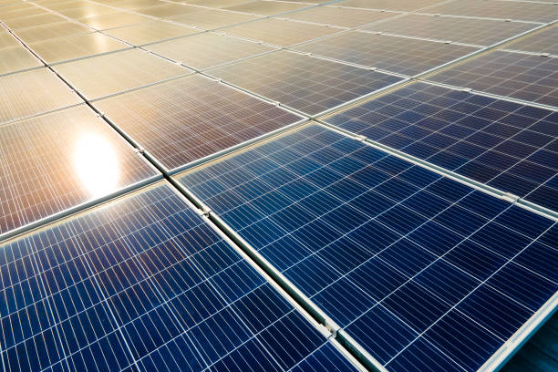 Aerial view of surface of blue photovoltaic solar panels mounted on building roof for producing clean ecological electricity. Production of renewable energy concept. stock photo