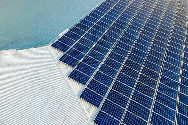 Aerial view of surface of blue photovoltaic solar panels mounted on building roof for producing clean ecological electricity. Production of renewable energy concept. stock photo