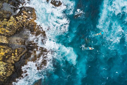 Aerial view of surfers on their surfboards.