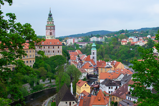 Aerial view of the Castle Tower in State Castle, the most famous symbol of Cesky Krumlov, and St. Jost Church, with colorful houses on the right (Czech Republic)