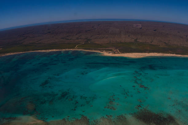 Aerial view of the road to theamazing Cape Range National Park, the coral reef and white sand formations of the Ningaloo Marine Park and the deep blue ocean beyond stock photo