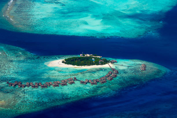aerial view of tropical paradise maldives island resort with coral reef turquoise blue ocean tourism background aerial view of tropical paradise maldives island resort with coral reef and turquoise blue ocean tourism background maldives stock pictures, royalty-free photos & images