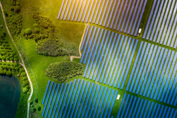 aerial view over solar cells energy farm in countryside landscape - central solar imagens e fotografias de stock