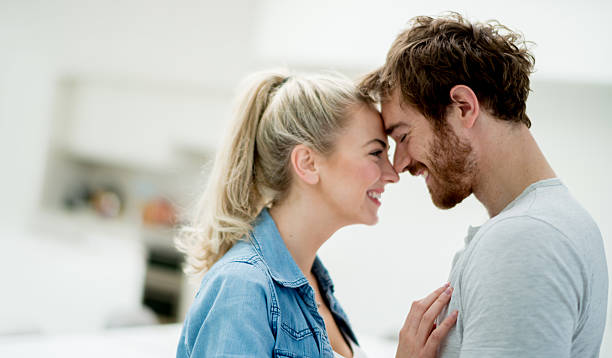 Affectionate couple looking happy at home Beautiful portrait of an affectionate couple looking happy at home - relationship concepts face to face stock pictures, royalty-free photos & images