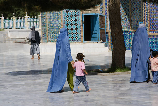 Afghan women walking with their children at the Blue Mosque. stock photo