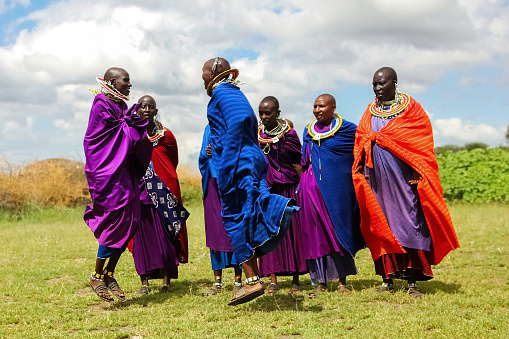 Africa: Masai women in colorful clothes perform a ritual dance