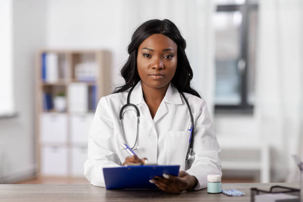 african american doctor with clipboard at hospital stock photo