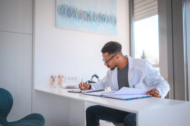 African American Doctor Writing A Medical Chart stock photo