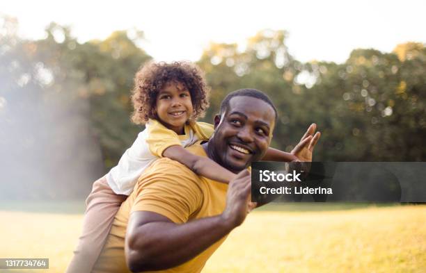African American father and daughter having fun outdoors.