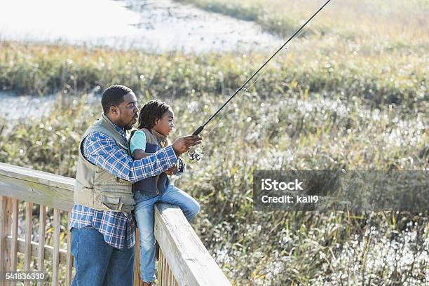 African American father and son fishing together