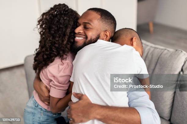 African american father hugging his little children