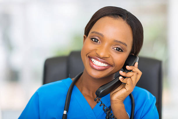 african american female nurse using landline phone - happy scrubs nurse phone bildbanksfoton och bilder