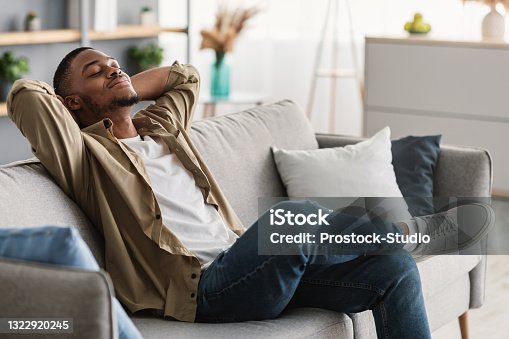 istock African American Guy Relaxing With Eyes Closed Sitting On Sofa Indoors 1322920245