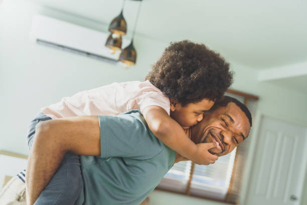 African American little boy kissing his Father, Happy family loving playing piggyback, Love emotion. stock photo