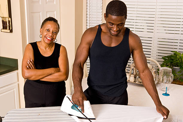 African American male ironing his shirt stock photo