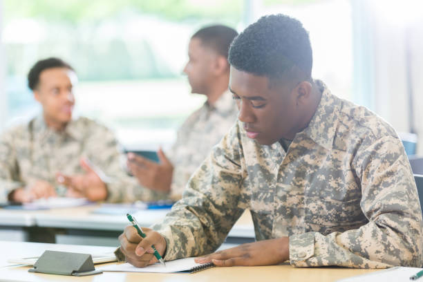 African American man takes class at military academy Confident young African American man takes a test while taking a class at a military academy. He is wearing camouflage clothing. military schools stock pictures, royalty-free photos & images