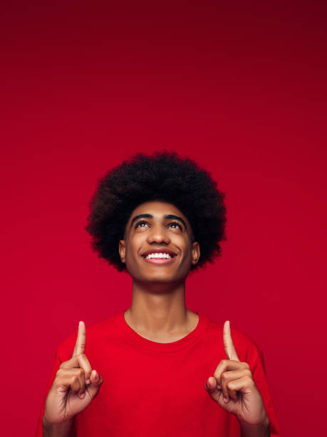 African american man with african hairstyle standing over isolated red background stock photo