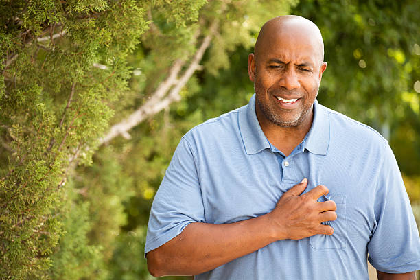 African American man with chest pains Mature African American man with chest pains clutching his heart. chest pain stock pictures, royalty-free photos & images