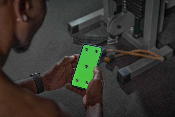 afroamerikaner mit greenscreen-telefon mit tracking-punkten. gym workout und sport-app zum trainieren - handy mockup coach stock-fotos und bilder