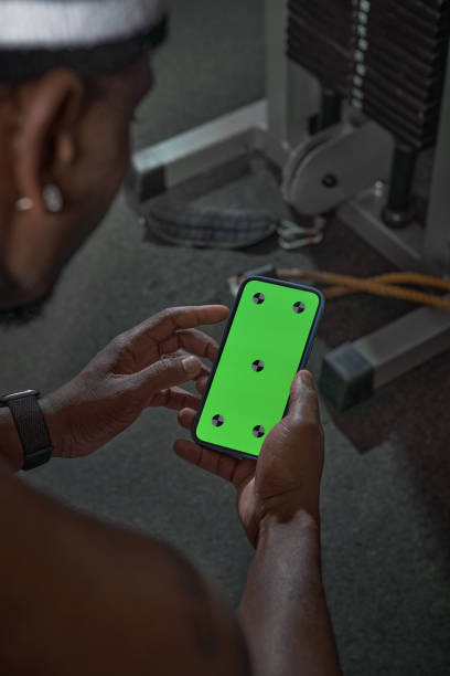 afroamerikaner mit telefon mit green screen mit tracking-punkten. gym workout und sport-app zum trainieren - handy mockup coach stock-fotos und bilder